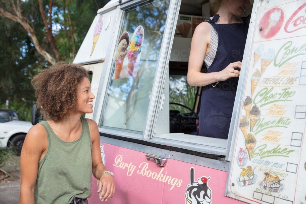 Woman waiting to be served ice cream cone from an ice cream truck - Australian Stock Image