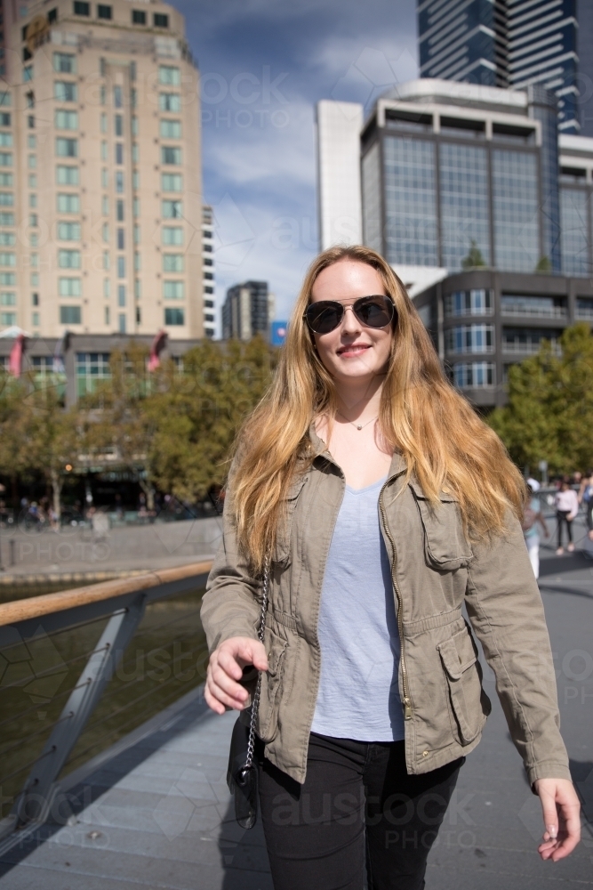 Woman walking in Melbourne city, in the Winter Sunshine - Australian Stock Image