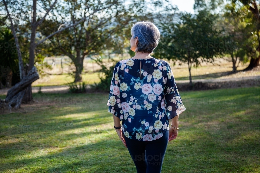 Woman walking through garden - Australian Stock Image