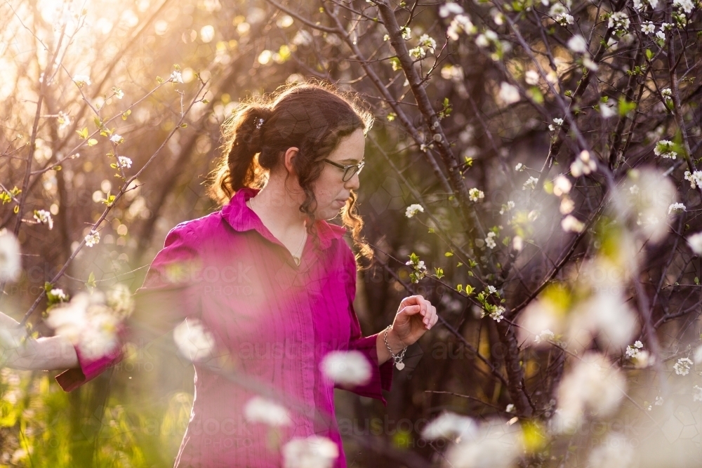 woman walking through magical blossom forest - Australian Stock Image