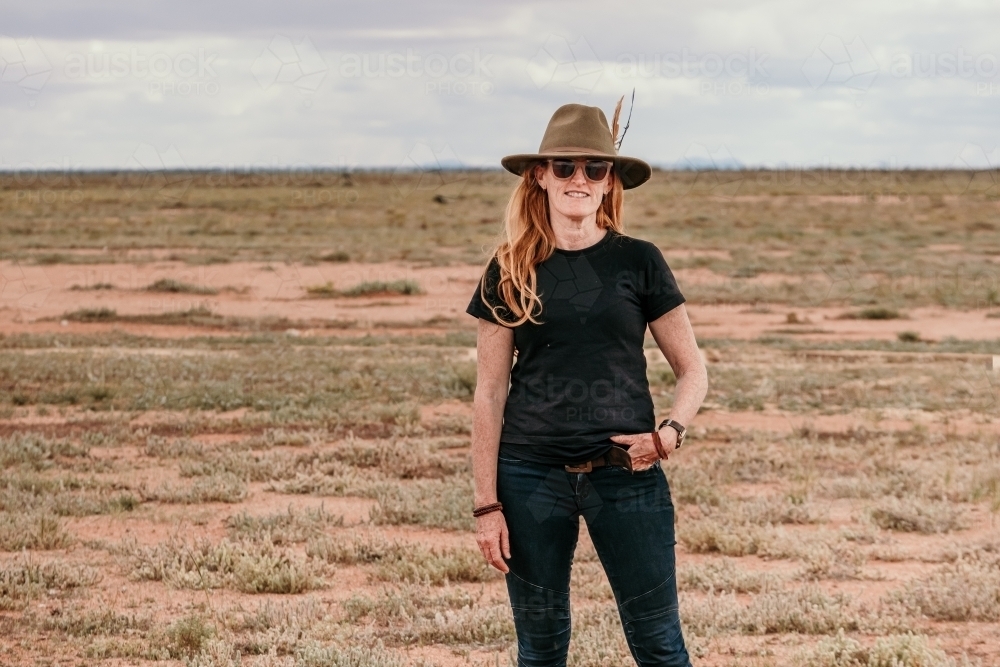 Woman wearing a hat standing in the outback. - Australian Stock Image