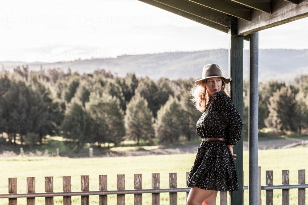 Woman wearing dress and hat on a farm during the afternoon - Australian Stock Image