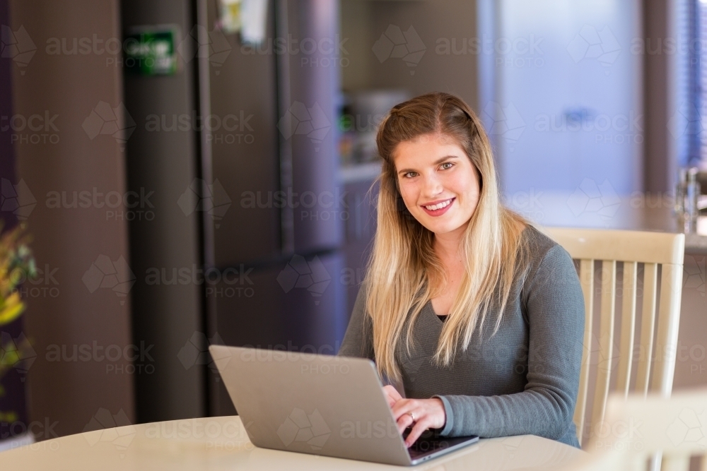 Woman working from home on laptop computer - Australian Stock Image