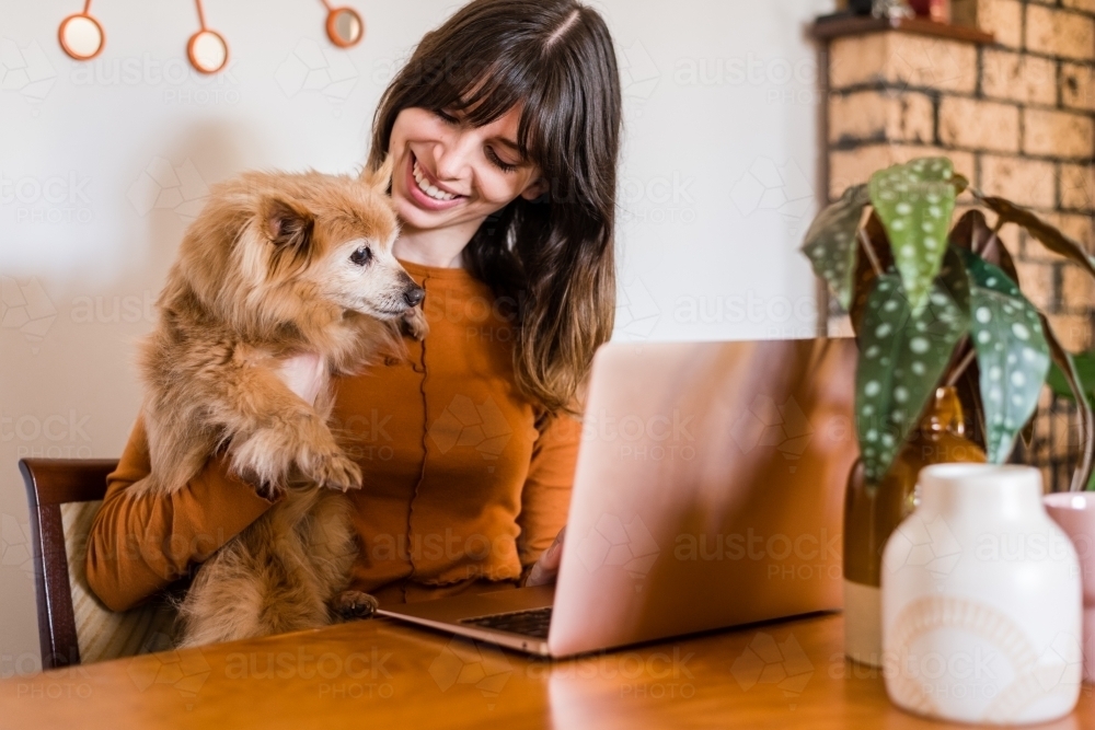 woman working from home, with pet dog - Australian Stock Image