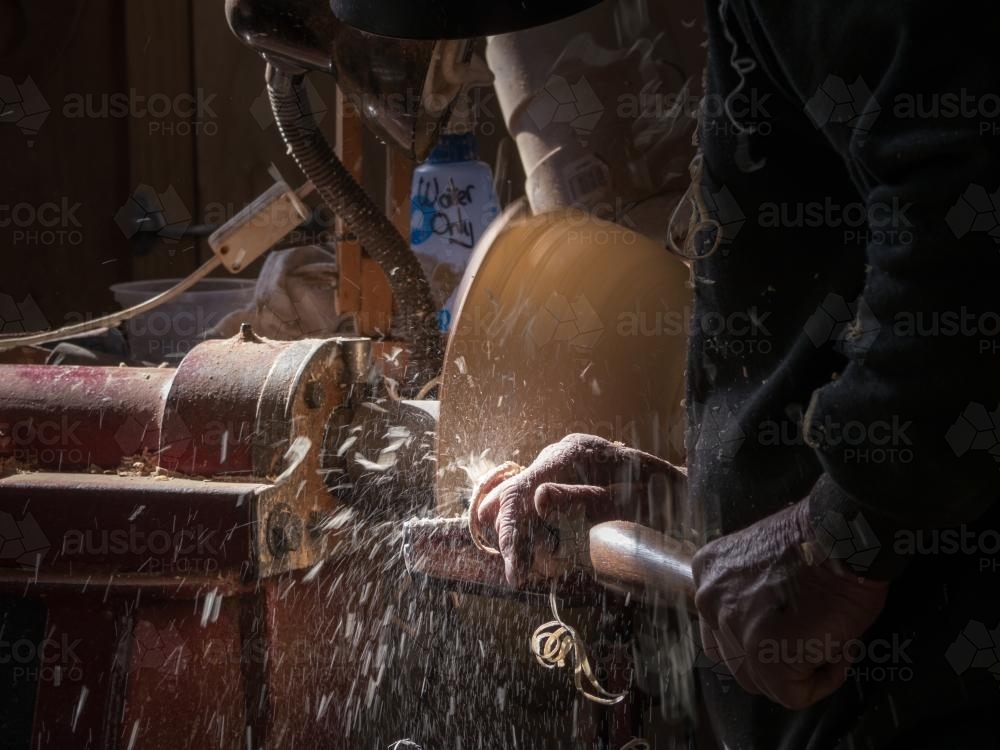 Wood turner using a lathe to make a bowl - Australian Stock Image