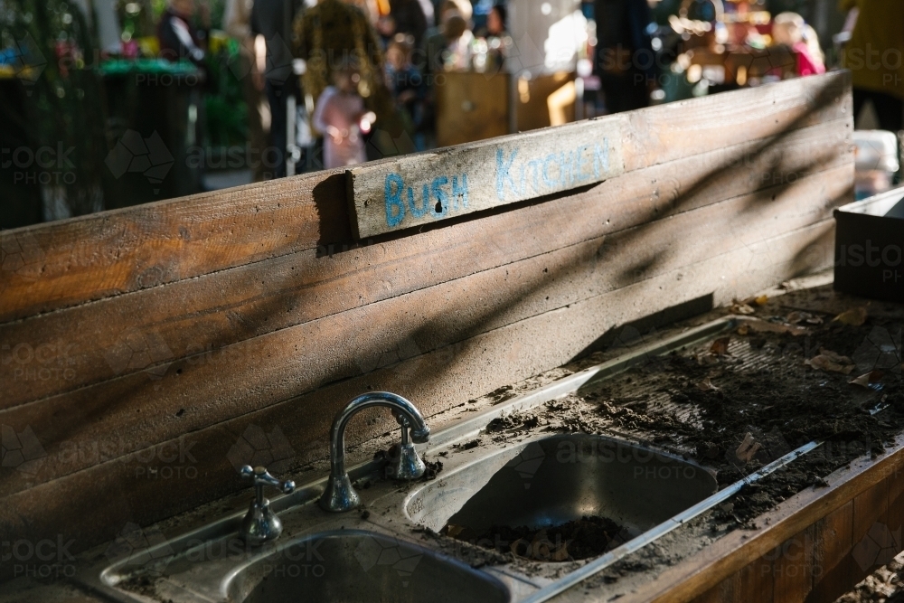 Wooden board with a dirty kitchen sink with soil and dead leaves - Australian Stock Image