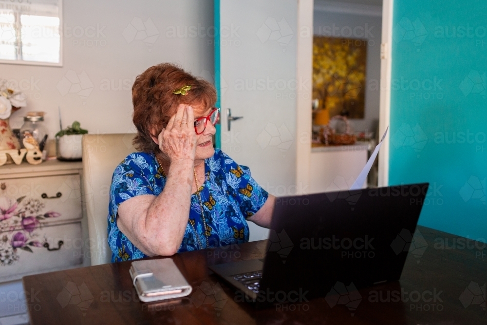 Worried, unsure senior woman with laptop stressed about paying bills - Australian Stock Image