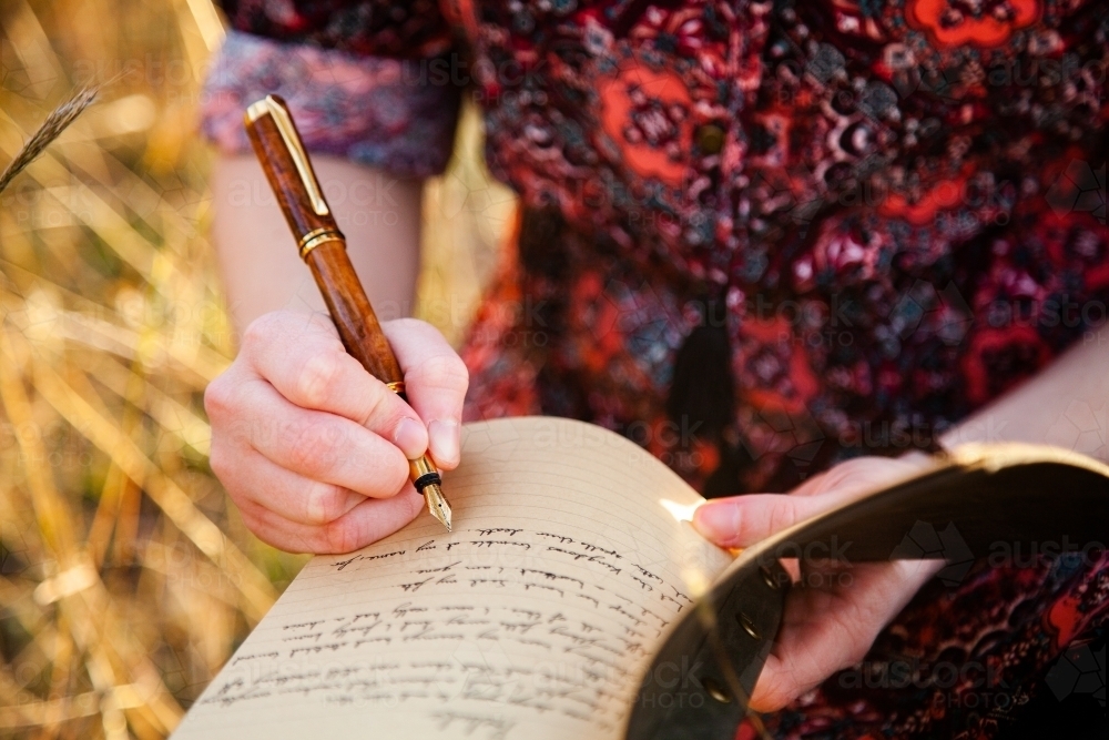 Writer holding fountain pen and notebook for writing in - Australian Stock Image