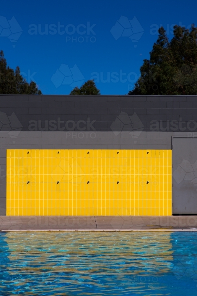Yellow tiles and outdoor showers at a swimming pool - Australian Stock Image