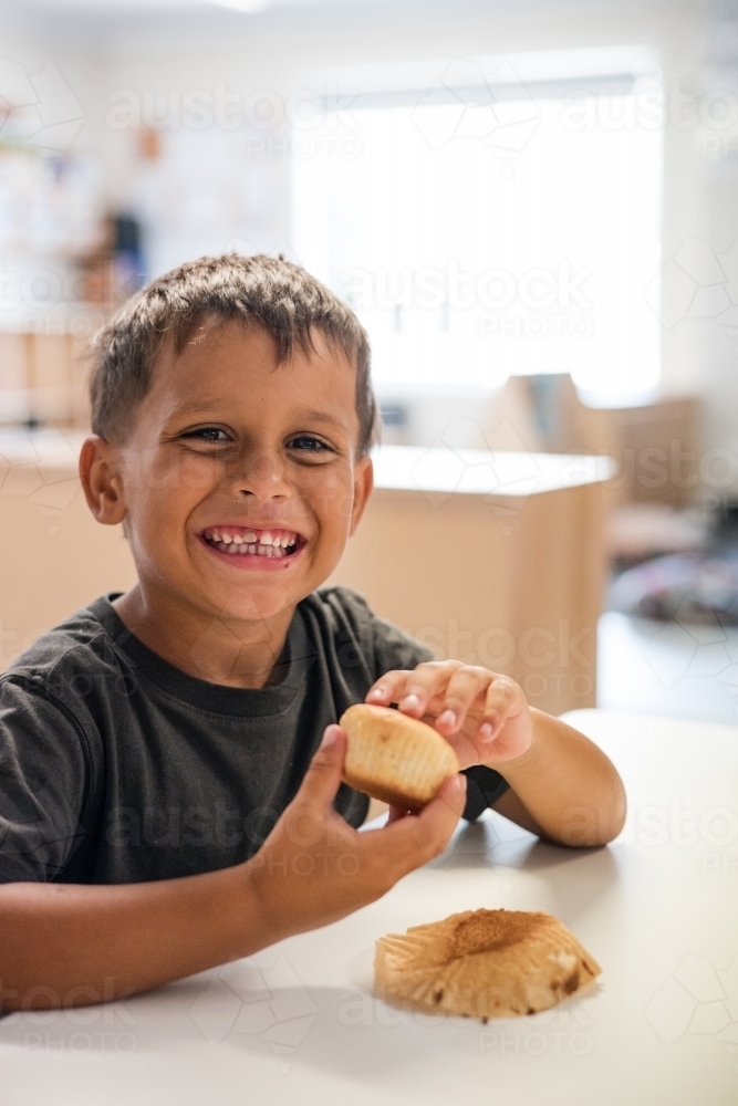 Young Aboriginal boy at preschool with cupcake - Australian Stock Image