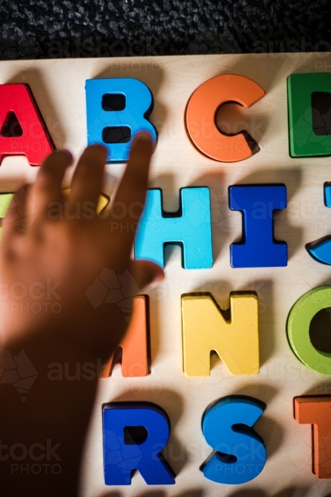 Young Aboriginal boy doing a letter puzzle - Australian Stock Image
