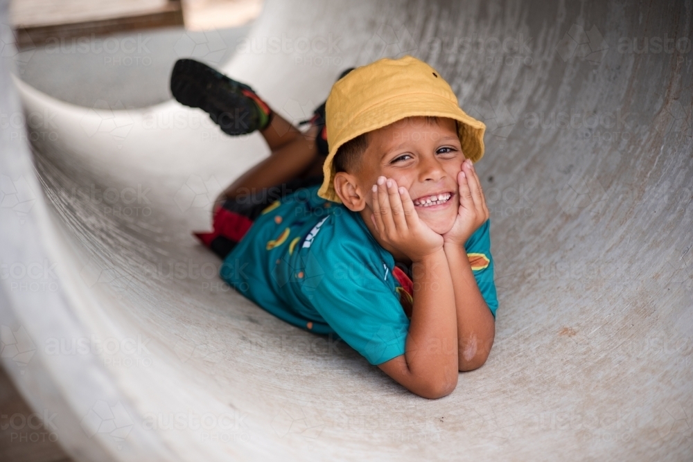 Young Aboriginal boy lying in a tunnel - Australian Stock Image