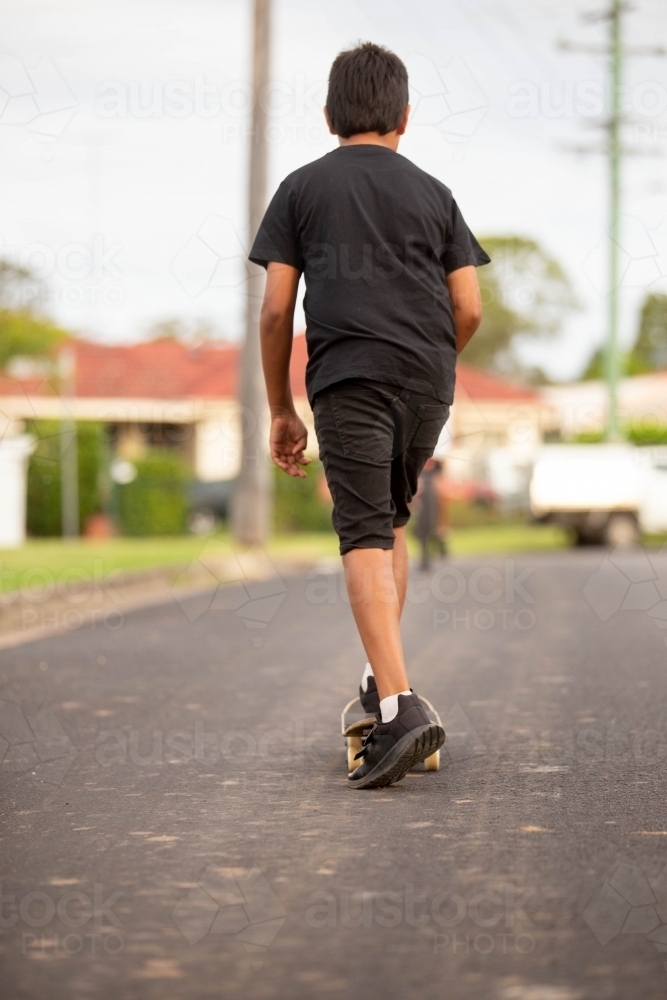 Young Aboriginal boy riding a skateboard - Australian Stock Image