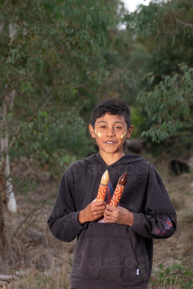 Young Aboriginal Boy with clapstick instrument - Australian Stock Image