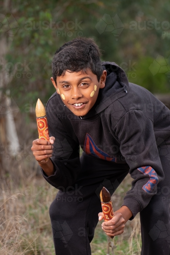 Young Aboriginal Boy with clapstick instrument - Australian Stock Image