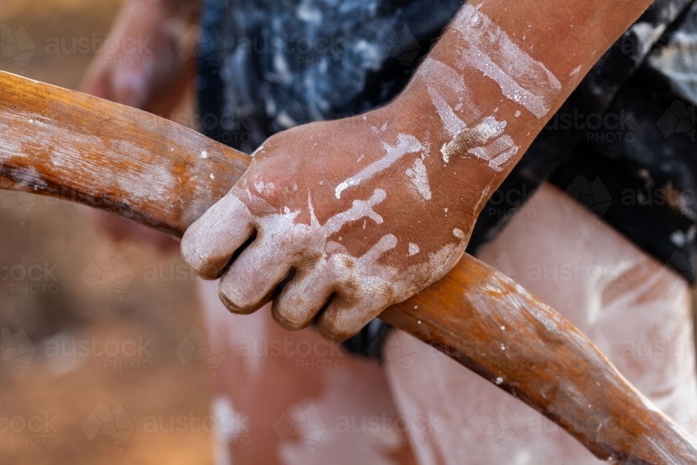 Young aboriginal persons hand holding wooden carved tool for digging and hunting - Australian Stock Image