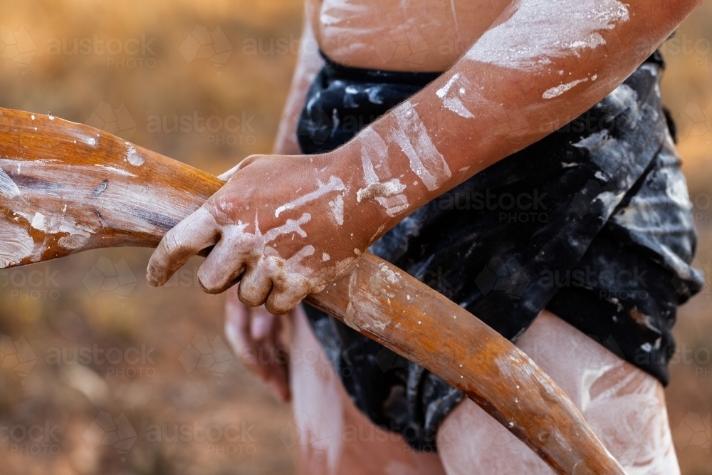 Young aboriginal persons hand holding wooden carved tool for digging and hunting - Australian Stock Image