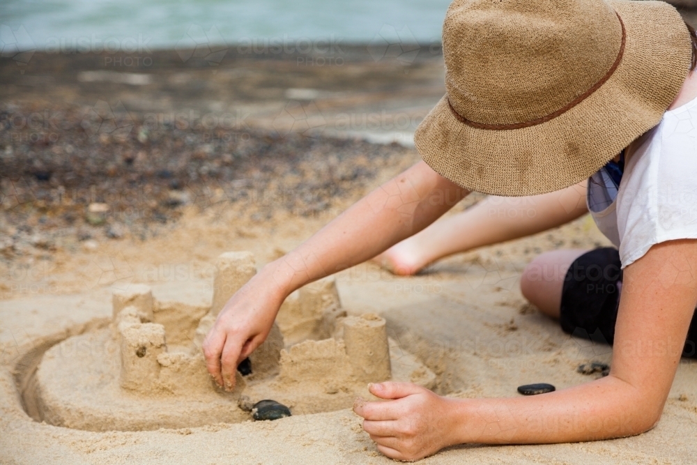 Young adult at the beach building a sand castle at Caves Beach Newcastle - Australian Stock Image