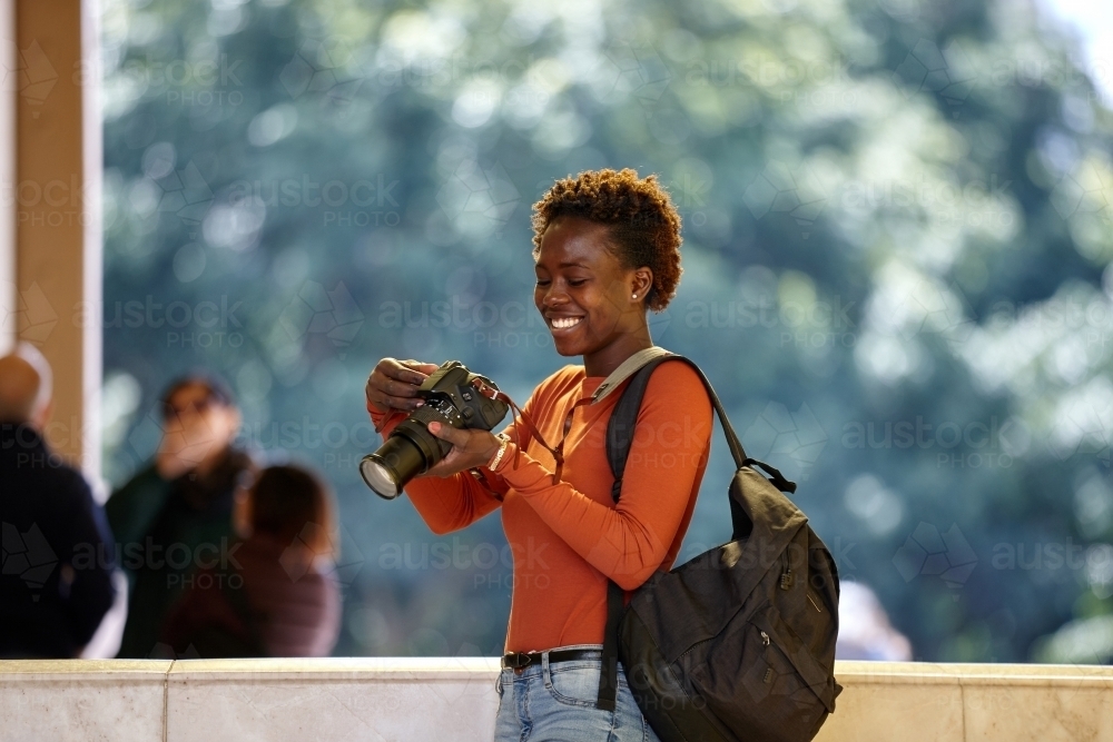 Young African woman photographer with backpack - Australian Stock Image