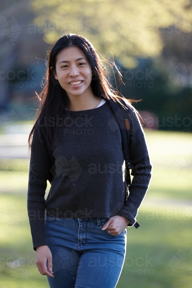 Young Asian female university student outdoors at park - Australian Stock Image