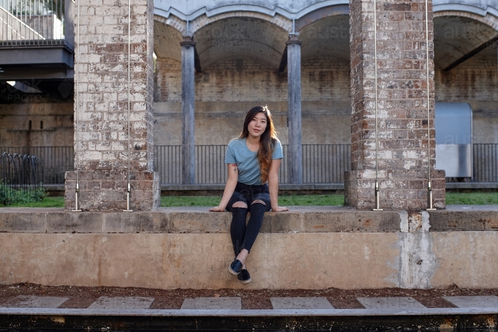 Young Asian woman enjoying time outdoors at enclave - Australian Stock Image