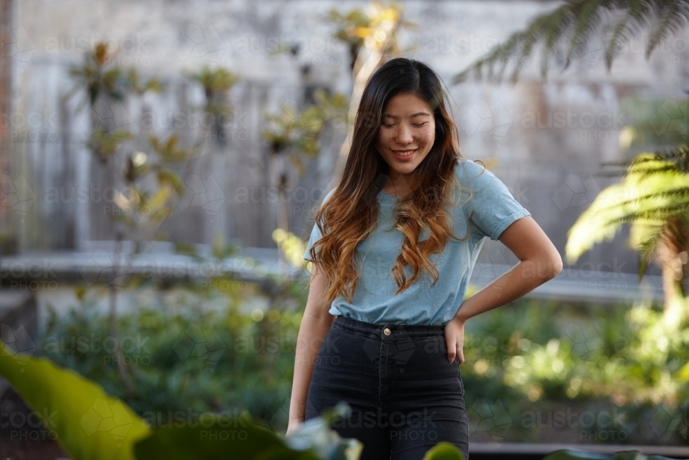 Young Asian woman enjoying time outdoors at enclave - Australian Stock Image