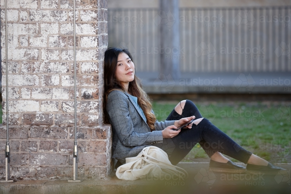 Young Asian woman enjoying time outdoors at enclave - Australian Stock Image