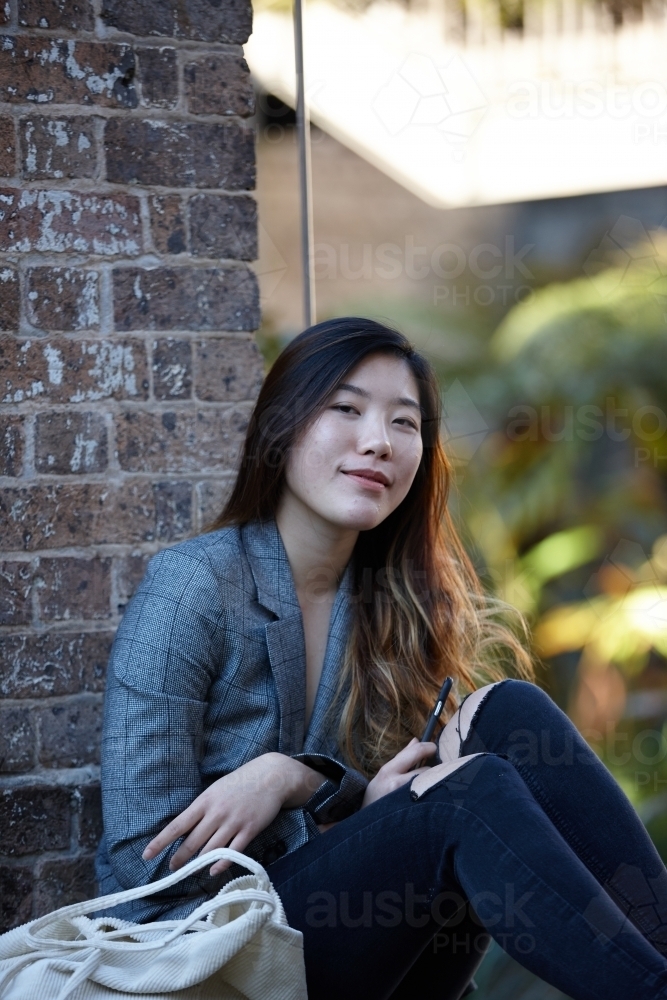 Young Asian woman enjoying time outdoors at enclave - Australian Stock Image