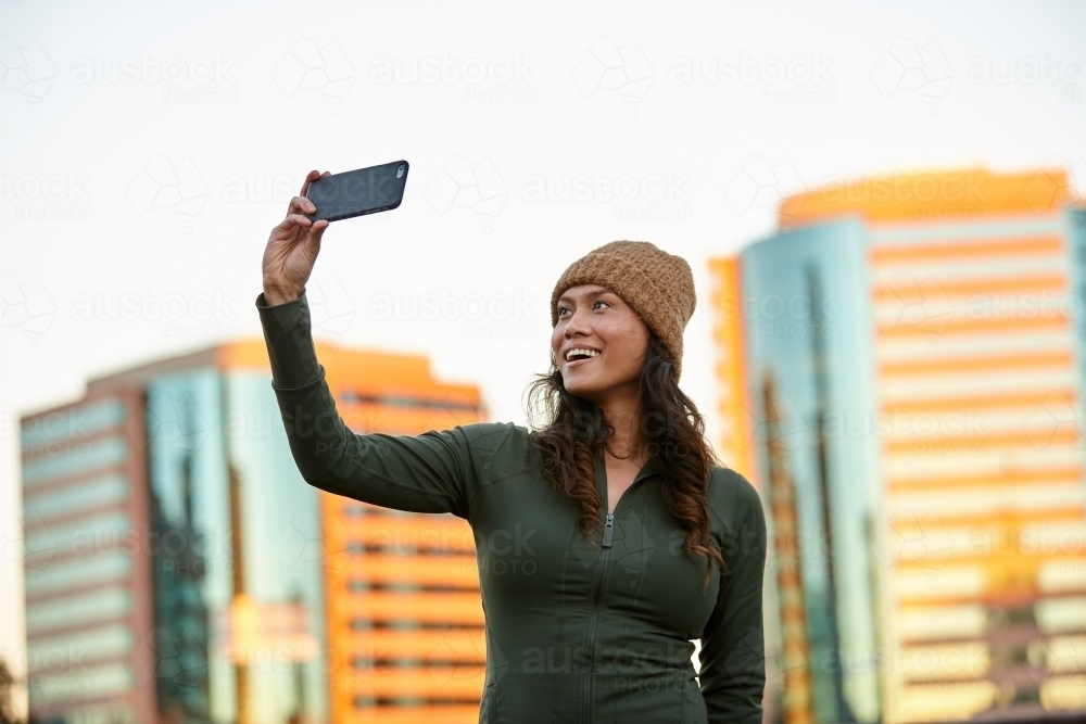 Young Asian woman having fun with mobile phone in city - Australian Stock Image