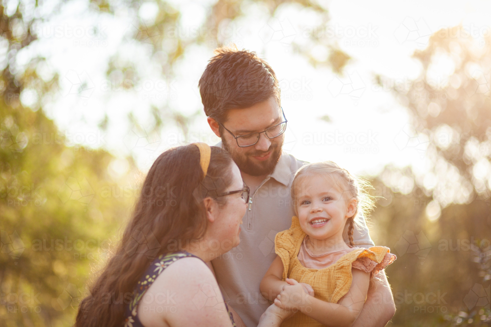 Young Australian family of three together in golden light of bushland - Australian Stock Image
