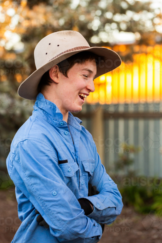 Young Australian teen boy laughing in backyard of country home - Australian Stock Image