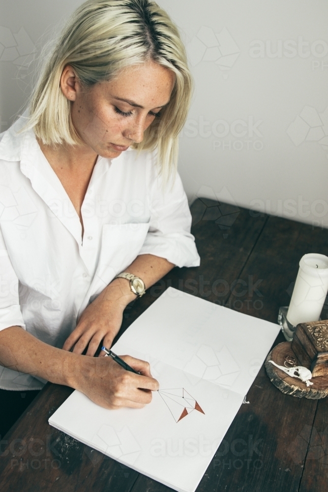 Teenage Girl Sitting At Desk Drawing In Sketchbook Portrait High