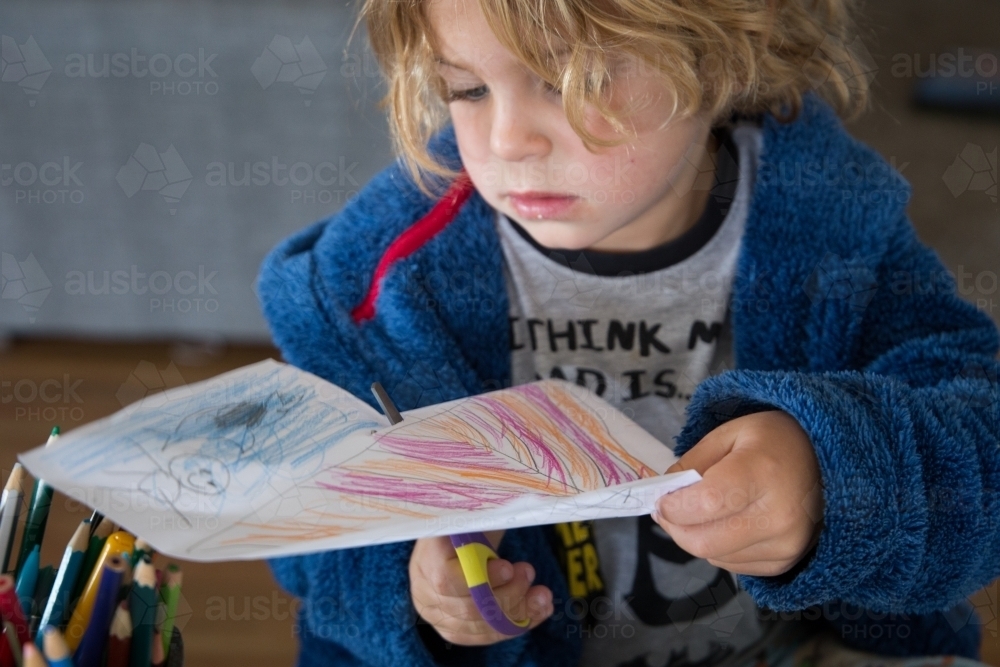 Young boy cutting picture - Australian Stock Image