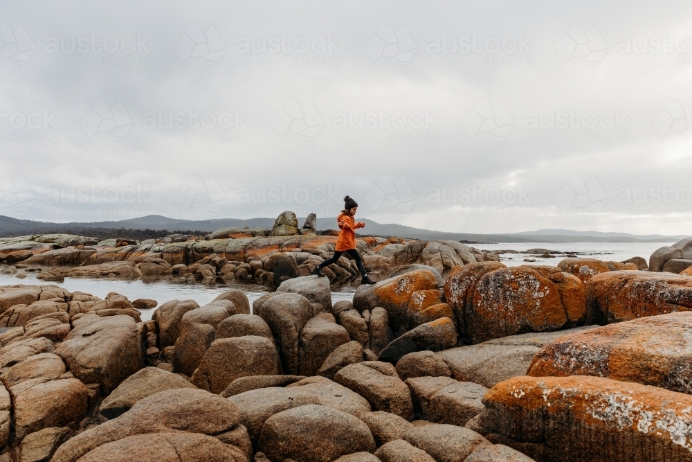 Young boy exploring coastal rocks - Australian Stock Image