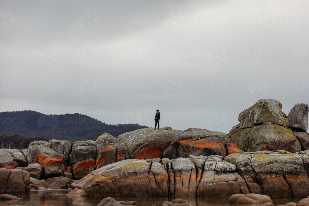 Young boy exploring coastal rocks - Australian Stock Image