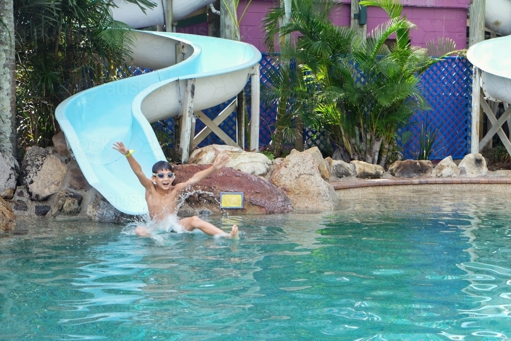 Young boy having fun on water slide - Australian Stock Image