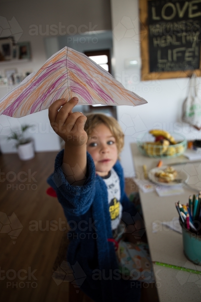 Young boy holding drawing of umbrella - Australian Stock Image