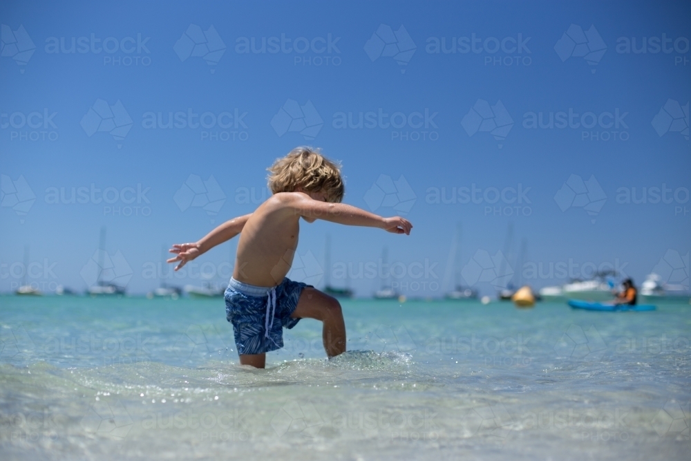 Young boy playing at beach - Australian Stock Image