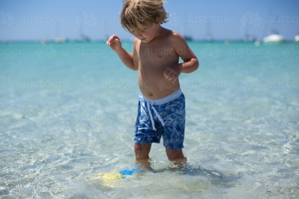 Young boy playing at beach - Australian Stock Image