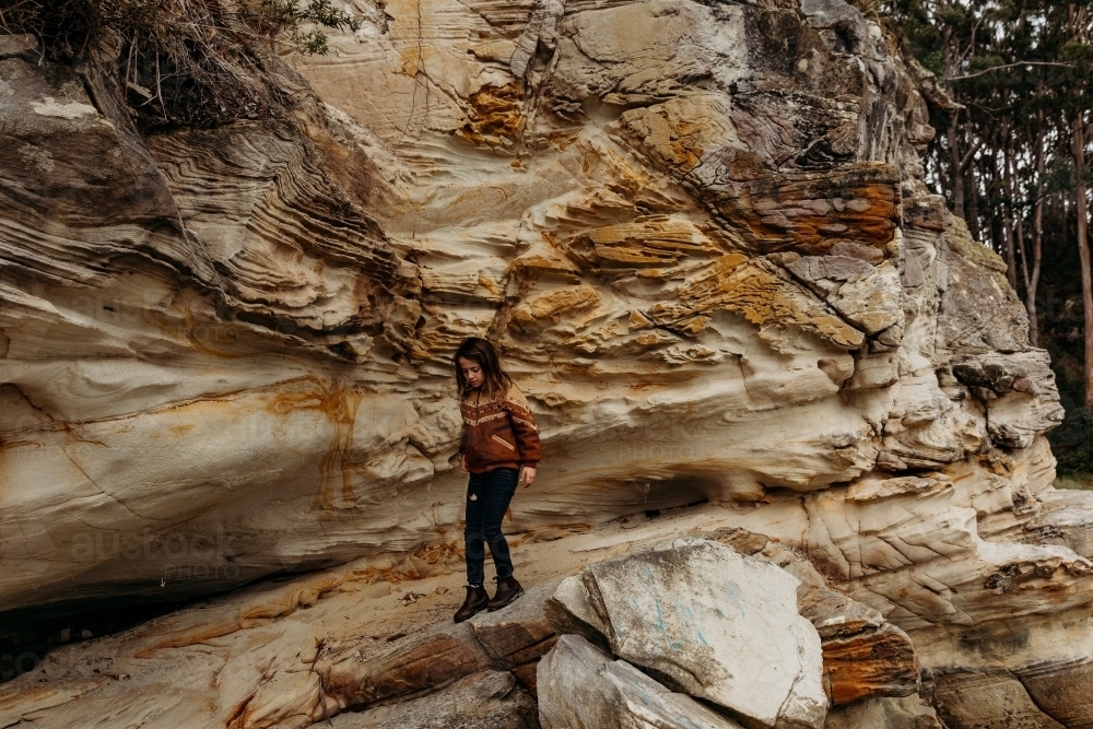 Young boy walking along cliffside - Australian Stock Image