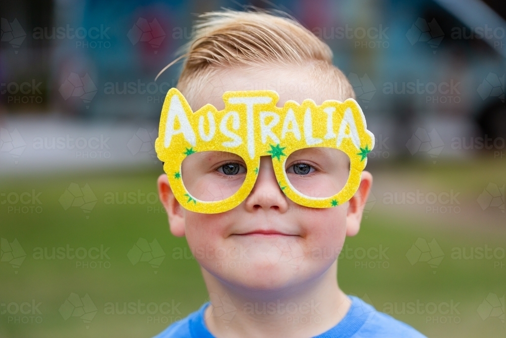 Young boy with glasses reading Australia on face at Australia Day eve event - Australian Stock Image