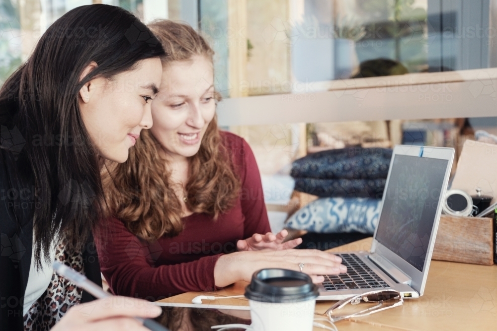 Young business women having casual meeting at coffee shop - Australian Stock Image