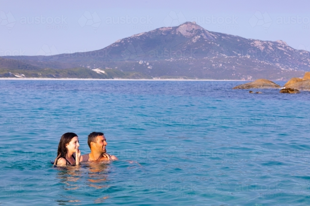 young couple enjoying cooling off in the ocean on a hot day - Australian Stock Image