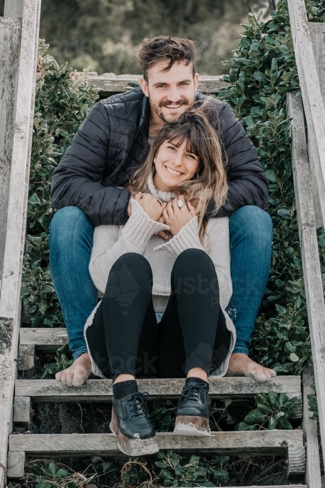 Young couple on the steps at the beach. - Australian Stock Image