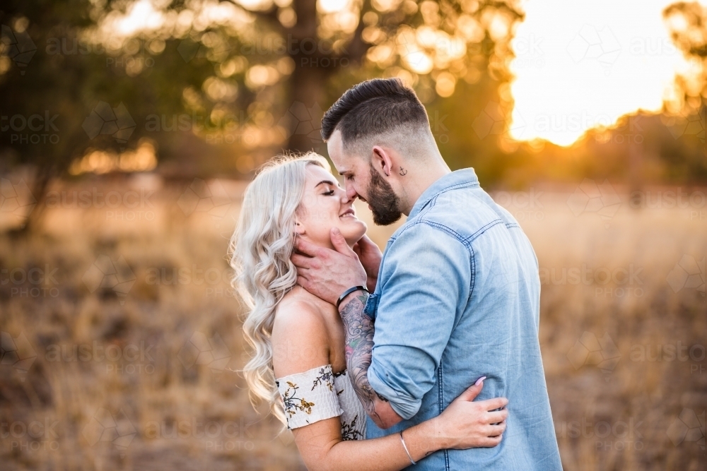 Image Of Young Couple Standing Arm In Arm Faces Close About To Kiss Austockphoto