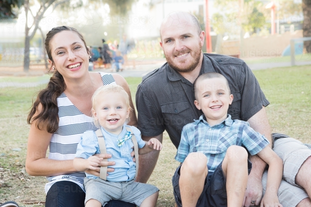 Young family smiling at camera relaxed. - Australian Stock Image