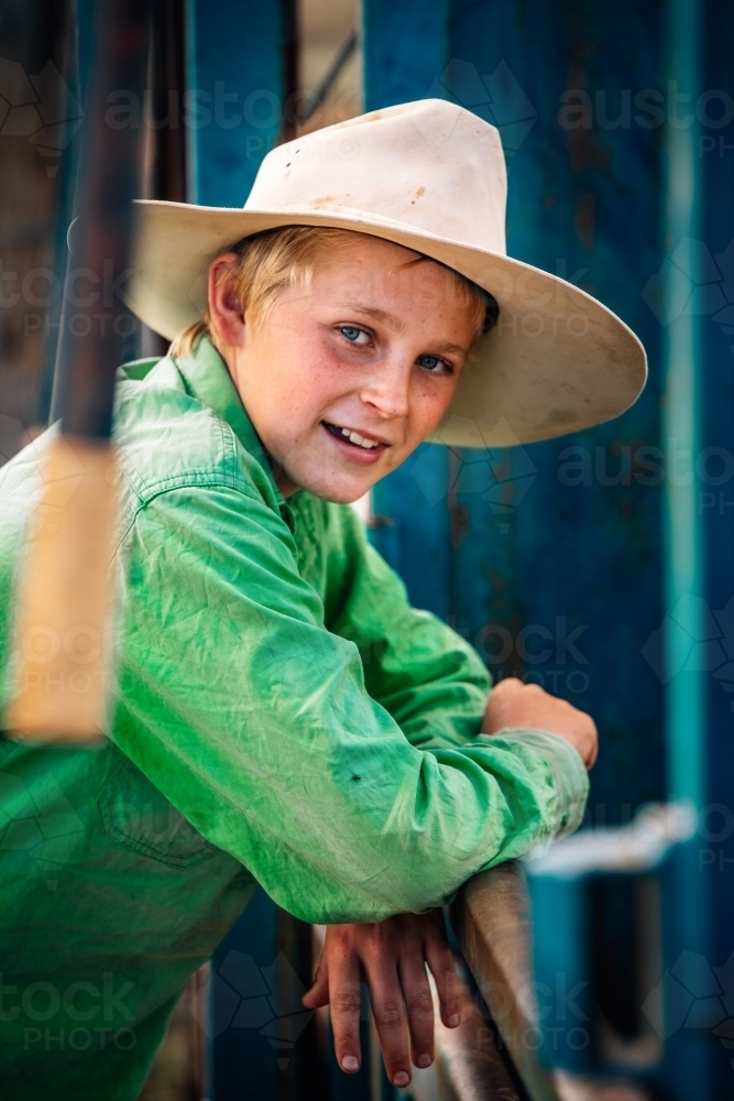 Young farmer leaning on the fence at the yards - Australian Stock Image