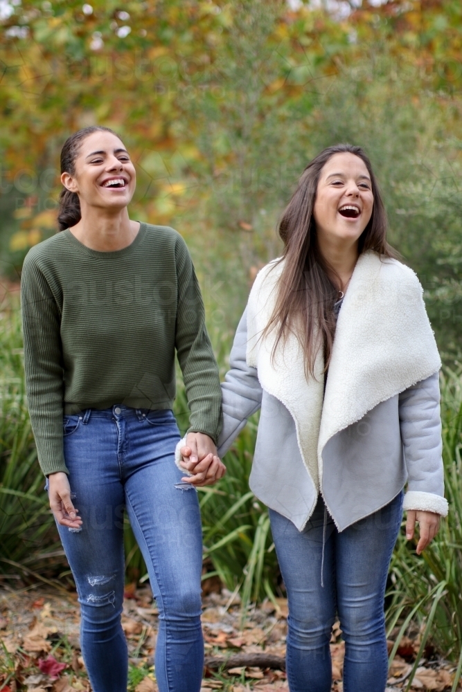 Young female same sex couple walking hand in hand - Australian Stock Image