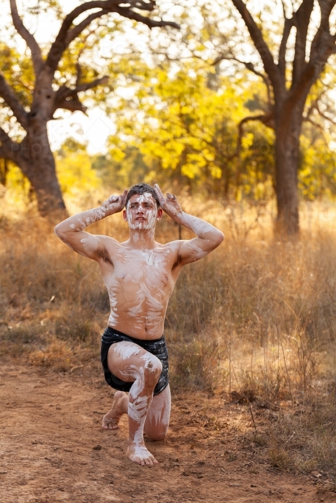 Young first nations Australian man performing aboriginals dance about kangaroos on country - Australian Stock Image