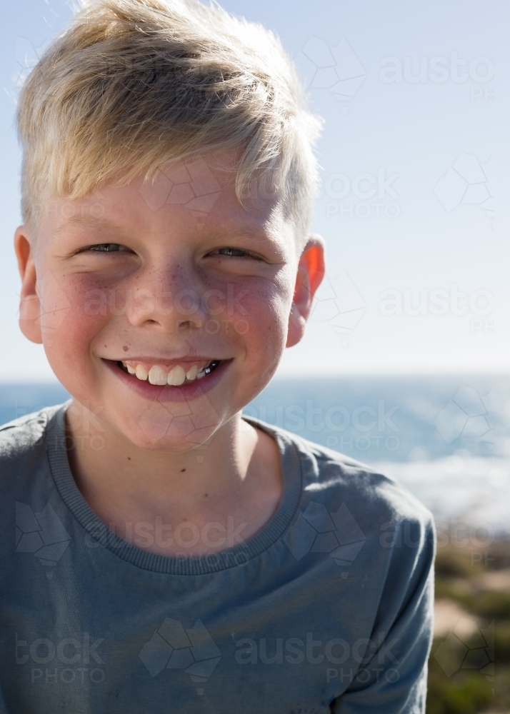 Young fresh faced boy smiling at camera - Australian Stock Image
